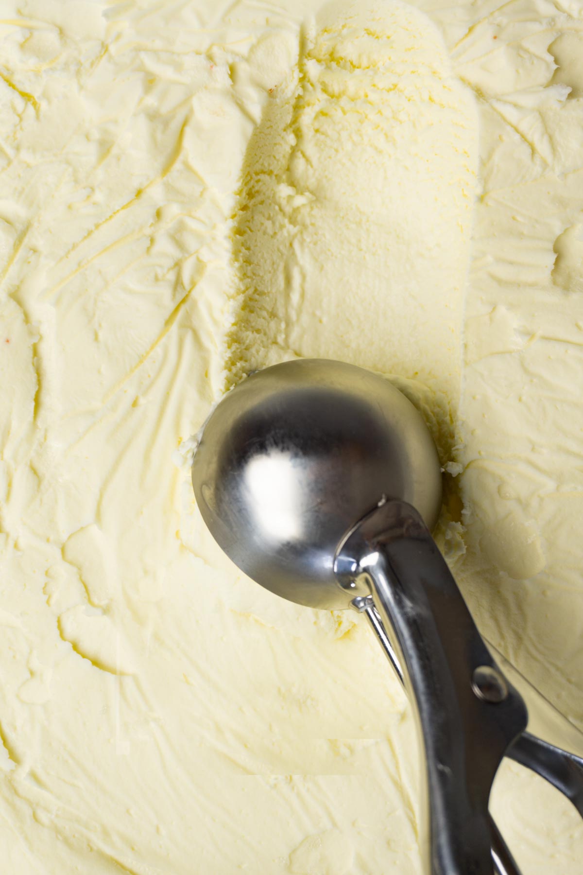 Scooping out vanilla ice cream with a cookie scoop.