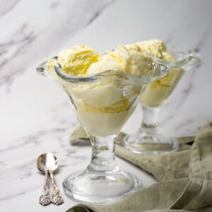 Two glass ice cream bowl filled with vanilla ice cream.