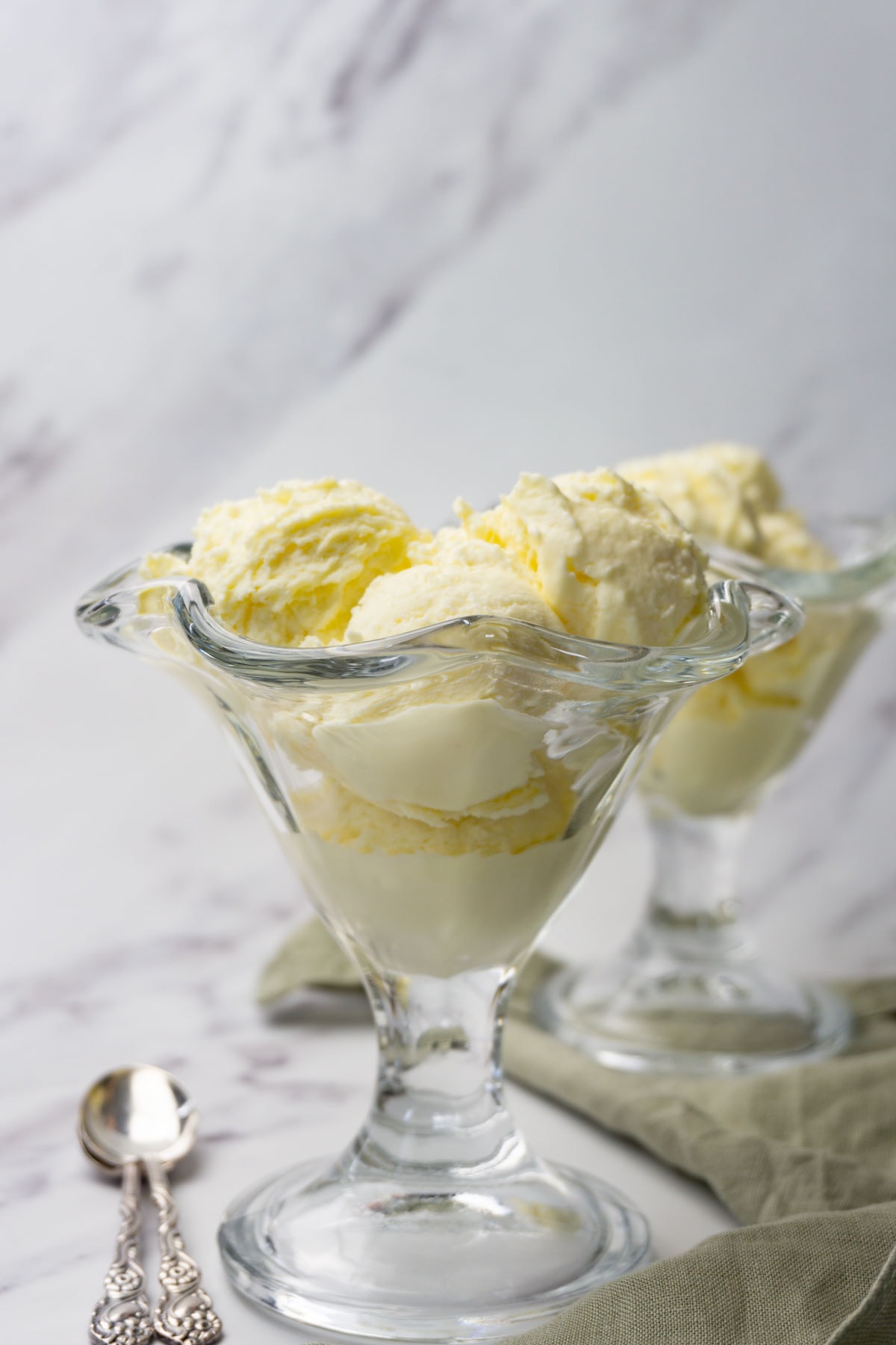 Two glass ice cream bowl filled with vanilla ice cream.