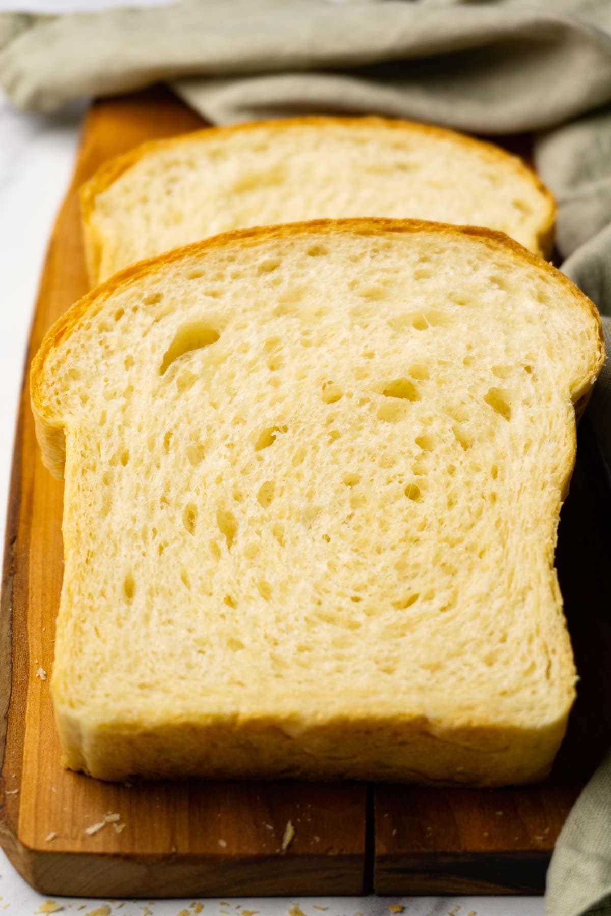 Two slices of bread on a wooden cutting board.