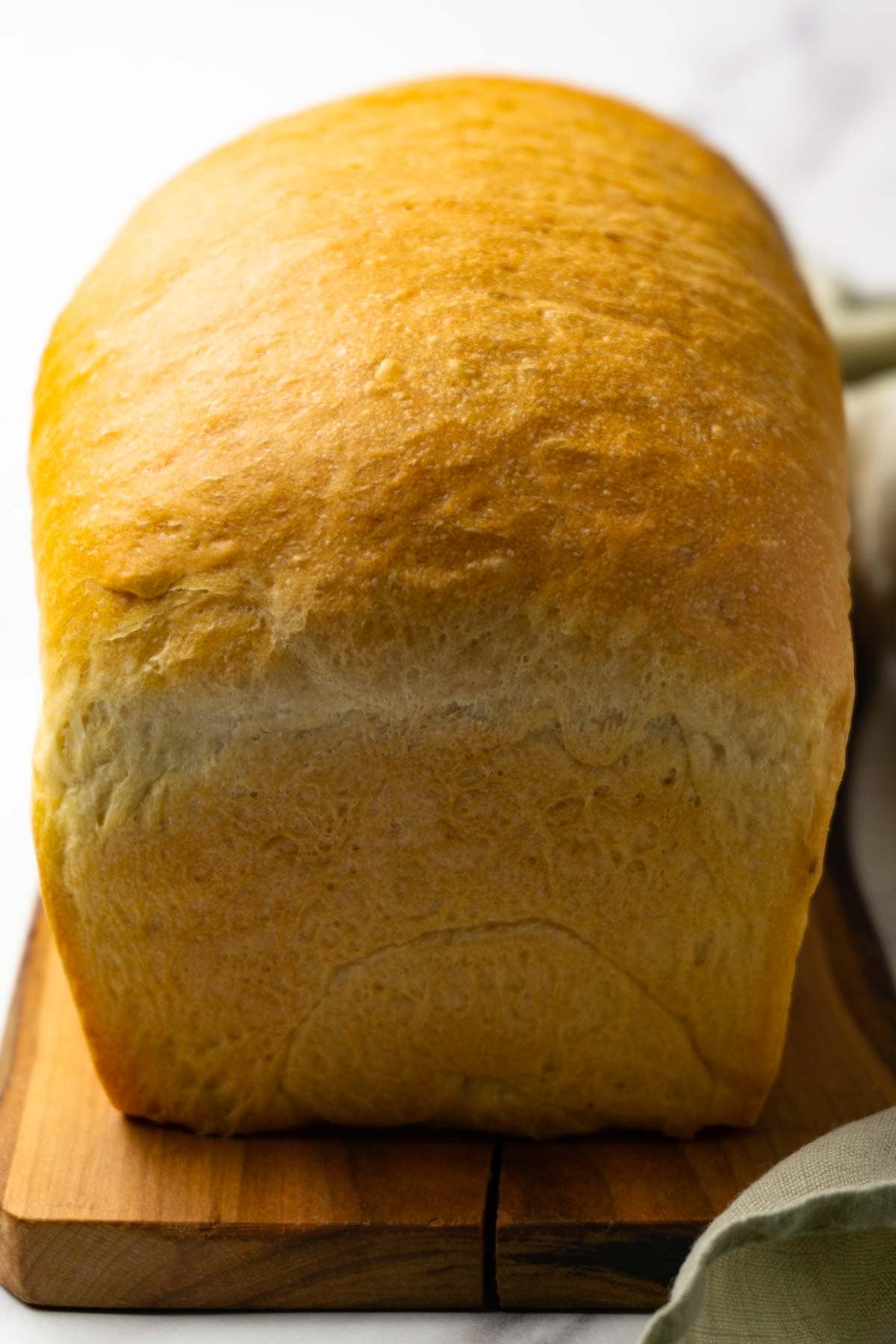 A loaf of bread on a wooden cutting board.