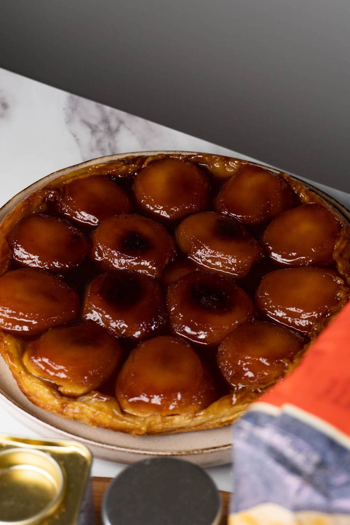 Apple tart with caramelised apples on a serving plate.