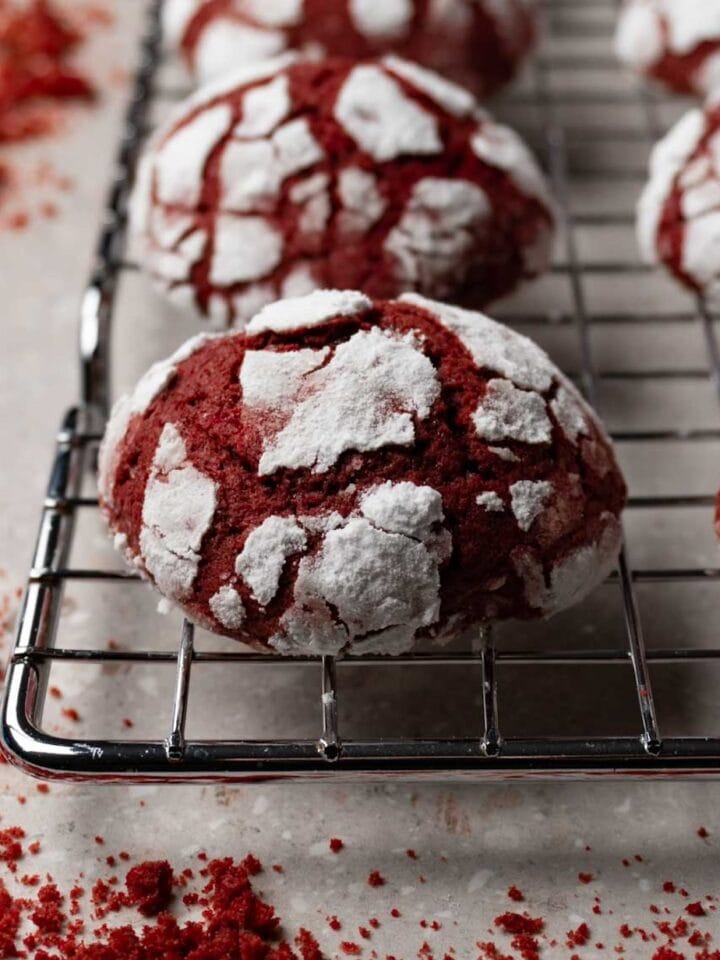 Red celvet crinkle cookies on a metal cooling rack.