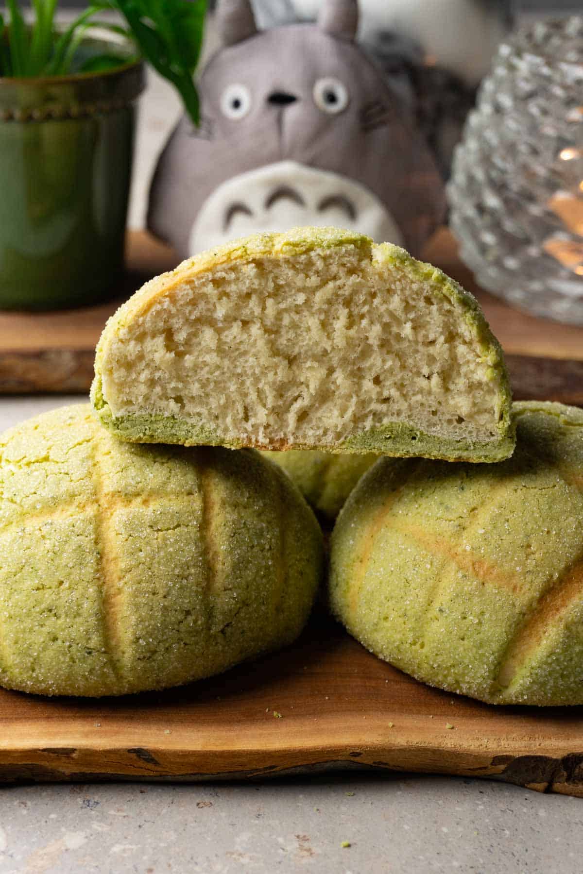 Green buns on a wooden board. One bun has been cut in half.