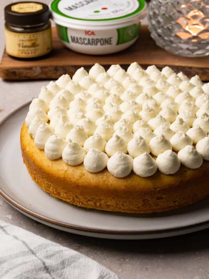 A single-layer cake with frosting piped on top, served on a large round plate.