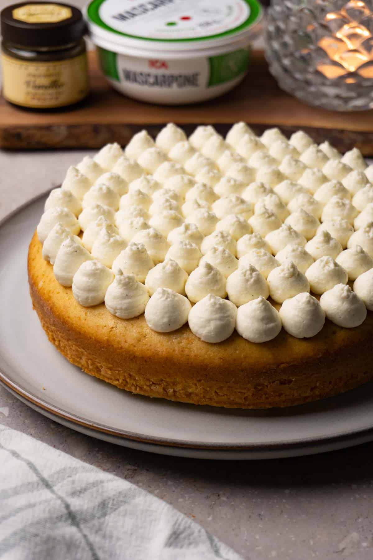 A single-layer cake with frosting piped on top, served on a large round plate.