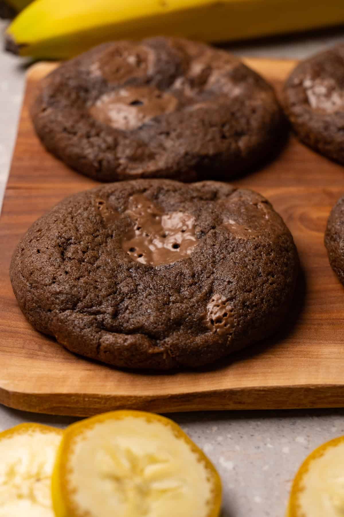 Chocolate cookies with chocolate chips on a wooden board.